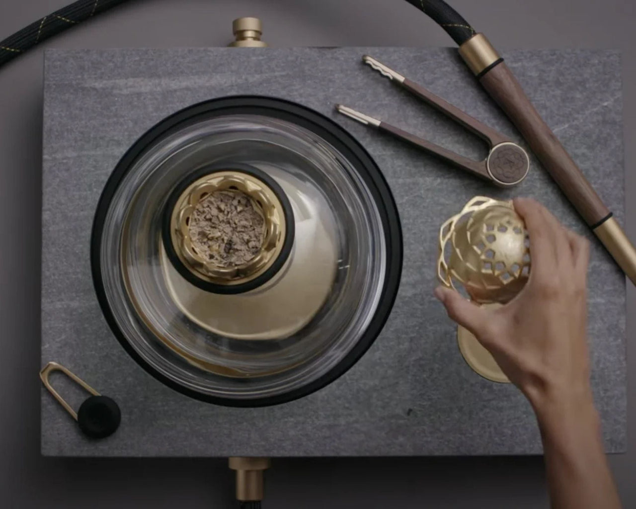 Overhead view of bowl inside glass dome with perforated heat cap held aside showing alignment over bowl opening