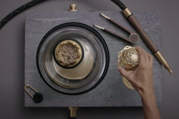 Overhead view of bowl inside glass dome with perforated heat cap held aside showing alignment over bowl opening