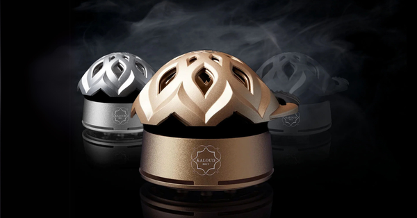 Three Kaloud Lotus hookah heat management devices in gold, silver and graphite, each with a vented petal-shaped lid on a metal base