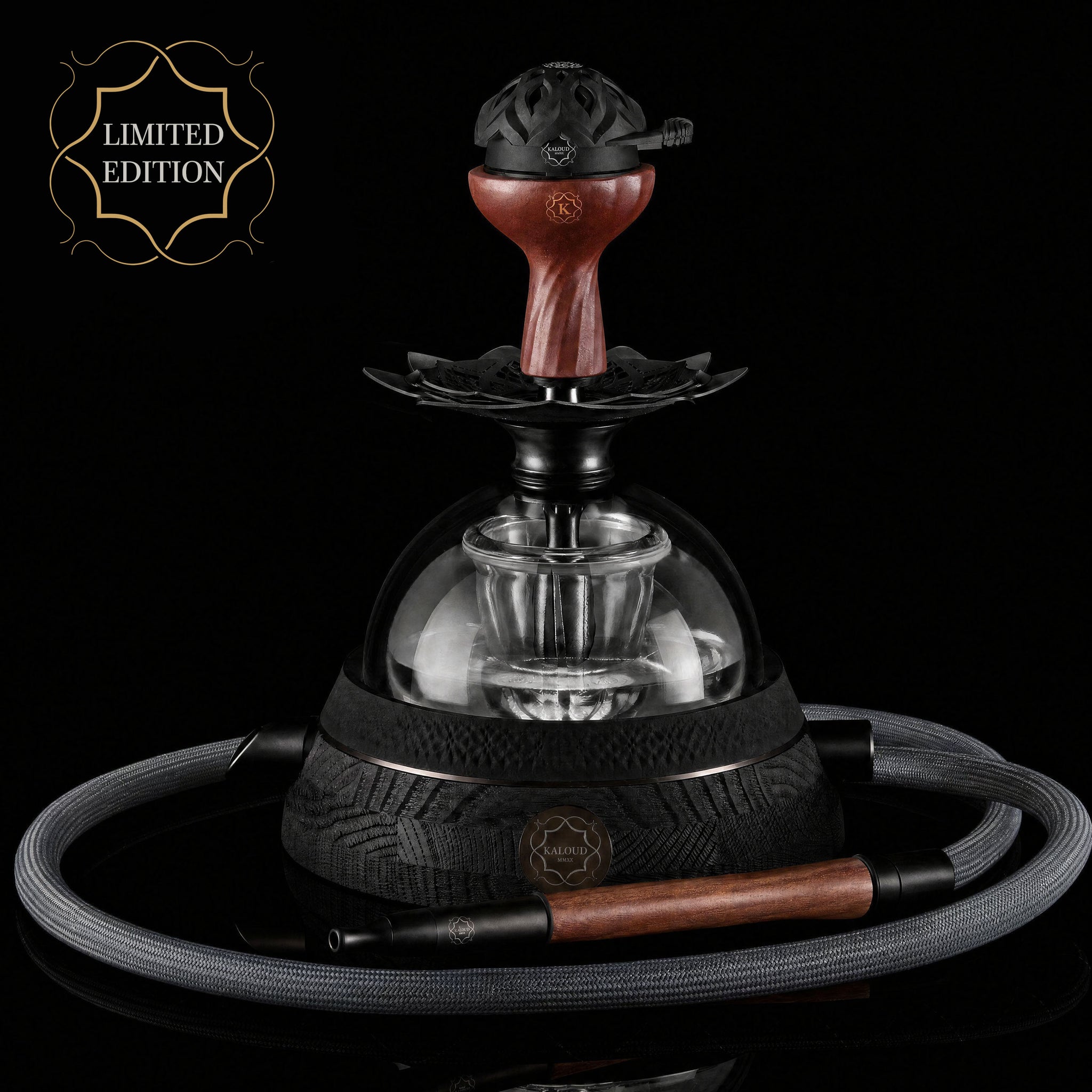A luxury hookah set from the brand MARSUN, featuring a black metal base with a clear glass dome, a reddish-brown wooden stem, and a matching coiled gray hose with a wooden mouthpiece. A gold 'LIMITED EDITION' badge is visible in the top left corner against a solid black background.